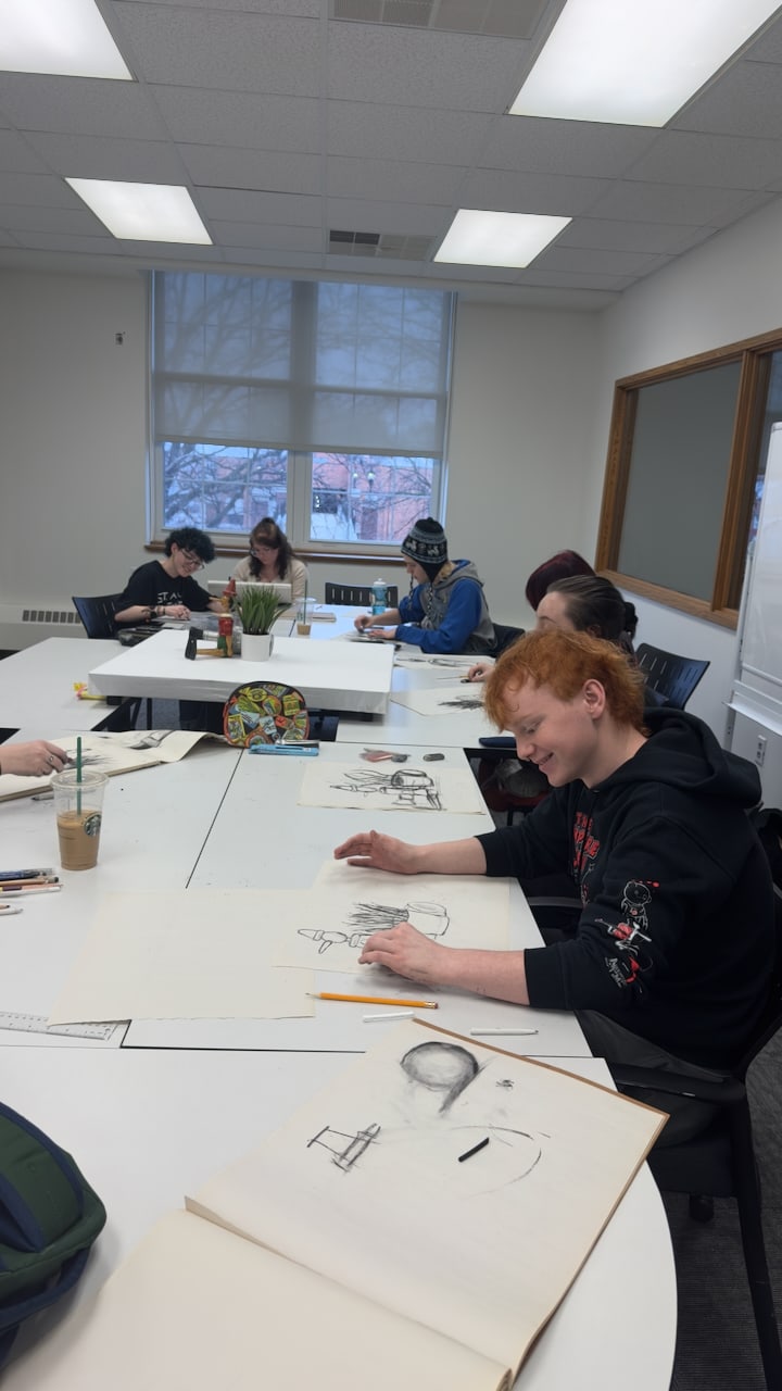 Students drawing around a studio classroom table