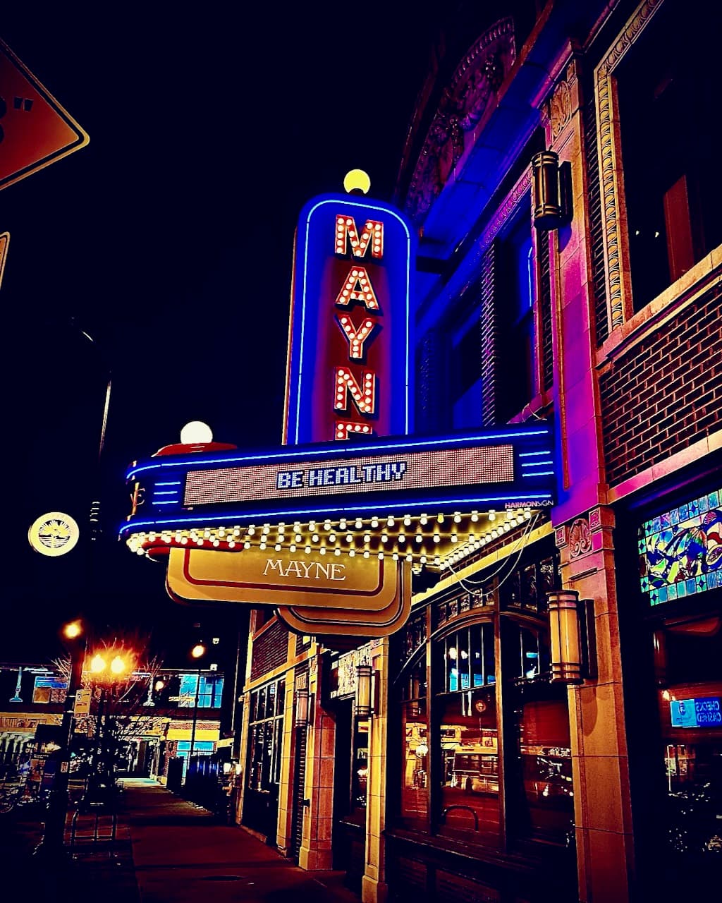 The Mayne theatre marquee glowing at night with blue and red neon.