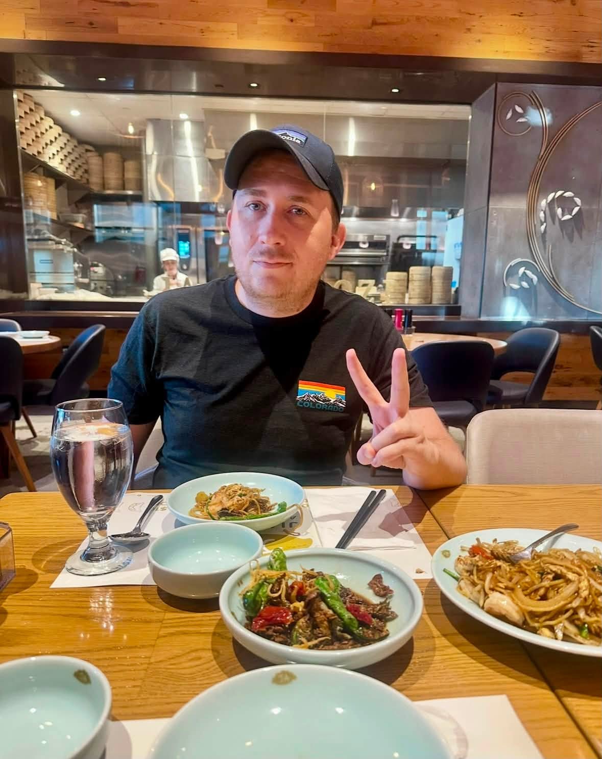 Brandon PT Davis at dinner, holding up a peace sign