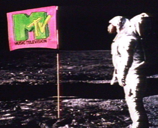 Astronaut standing beside an MTV flag planted on the moon.