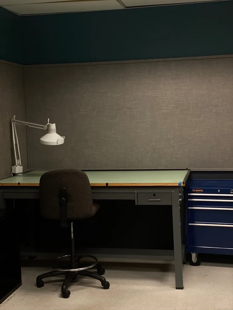 Drafting table, task lamp, chair, and tool chest in the studio