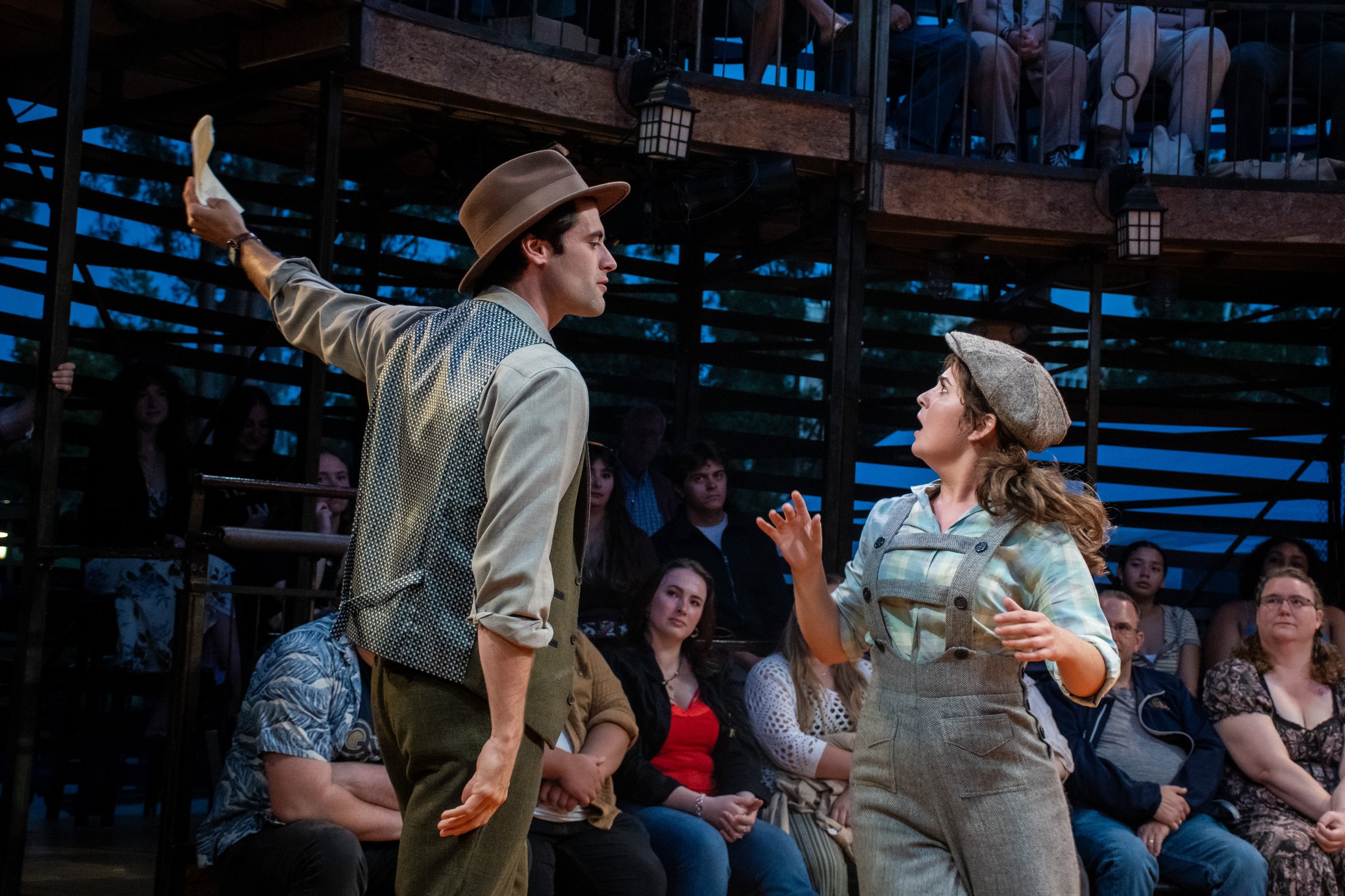 Two performers confront one another beside the audience in New Swan’s theatre in the round.