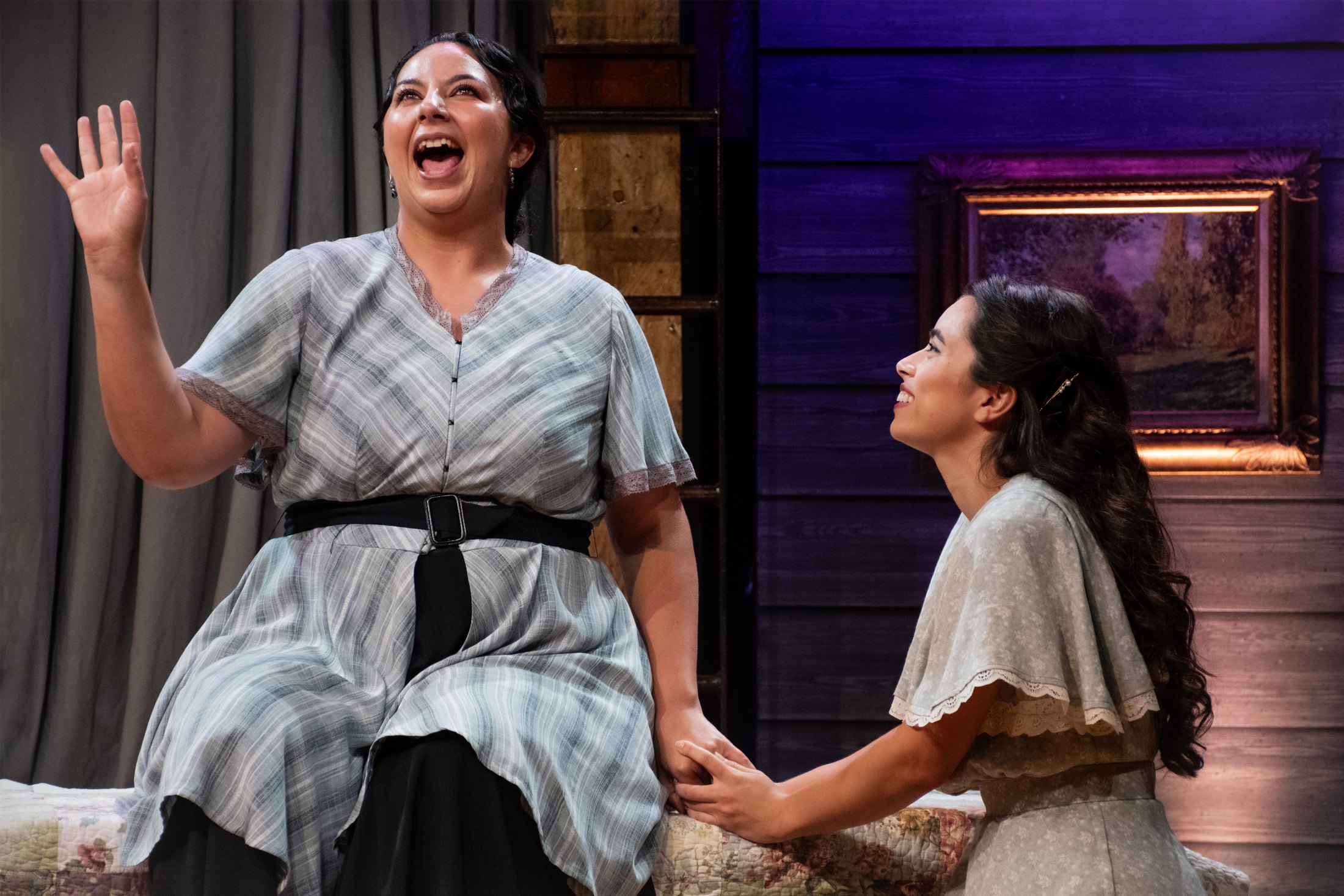 Juliet and the Nurse share a joyful moment against the central architecture.