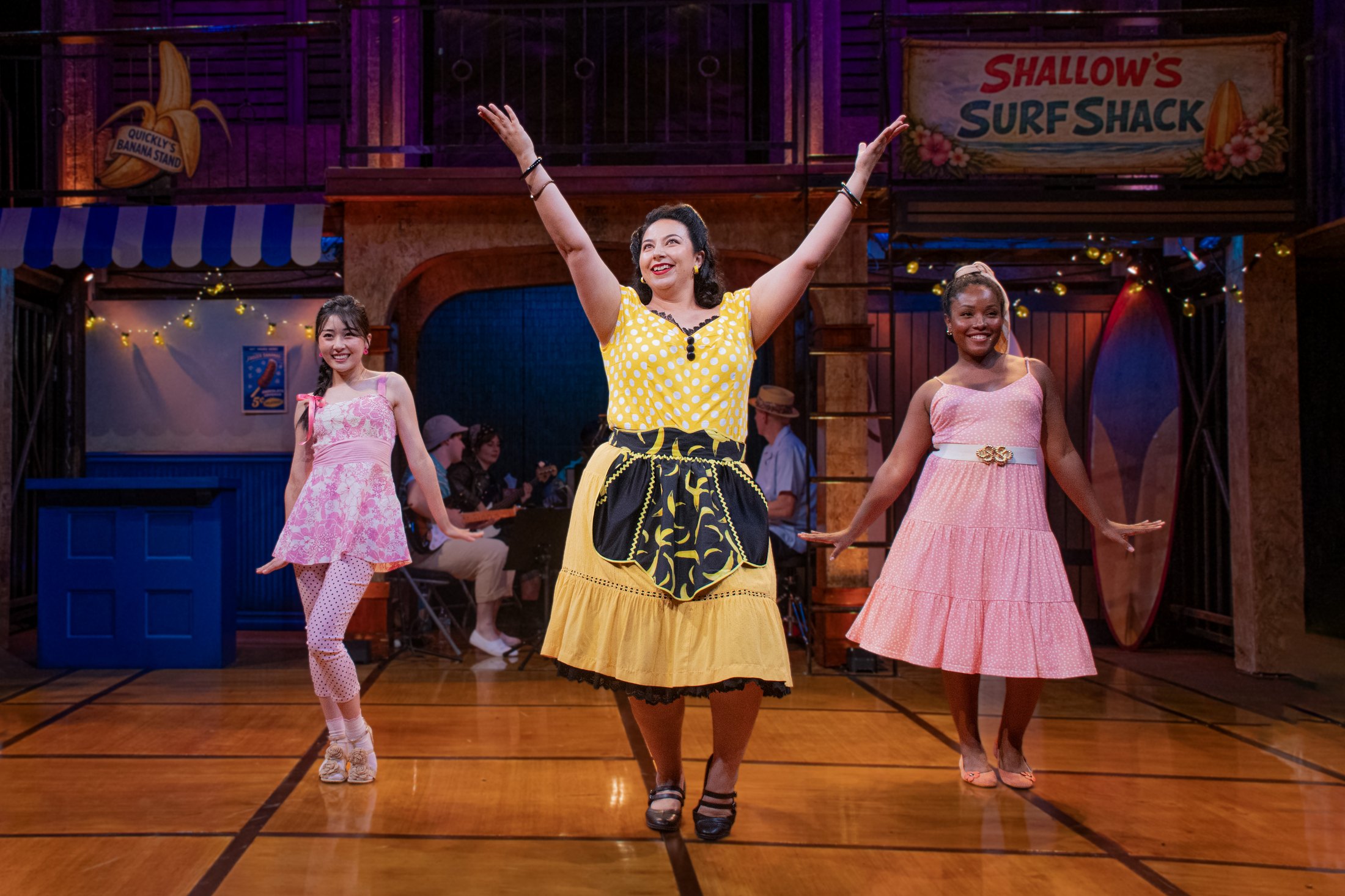 Three performers dance across the central floor of the Windsor Cove setting.