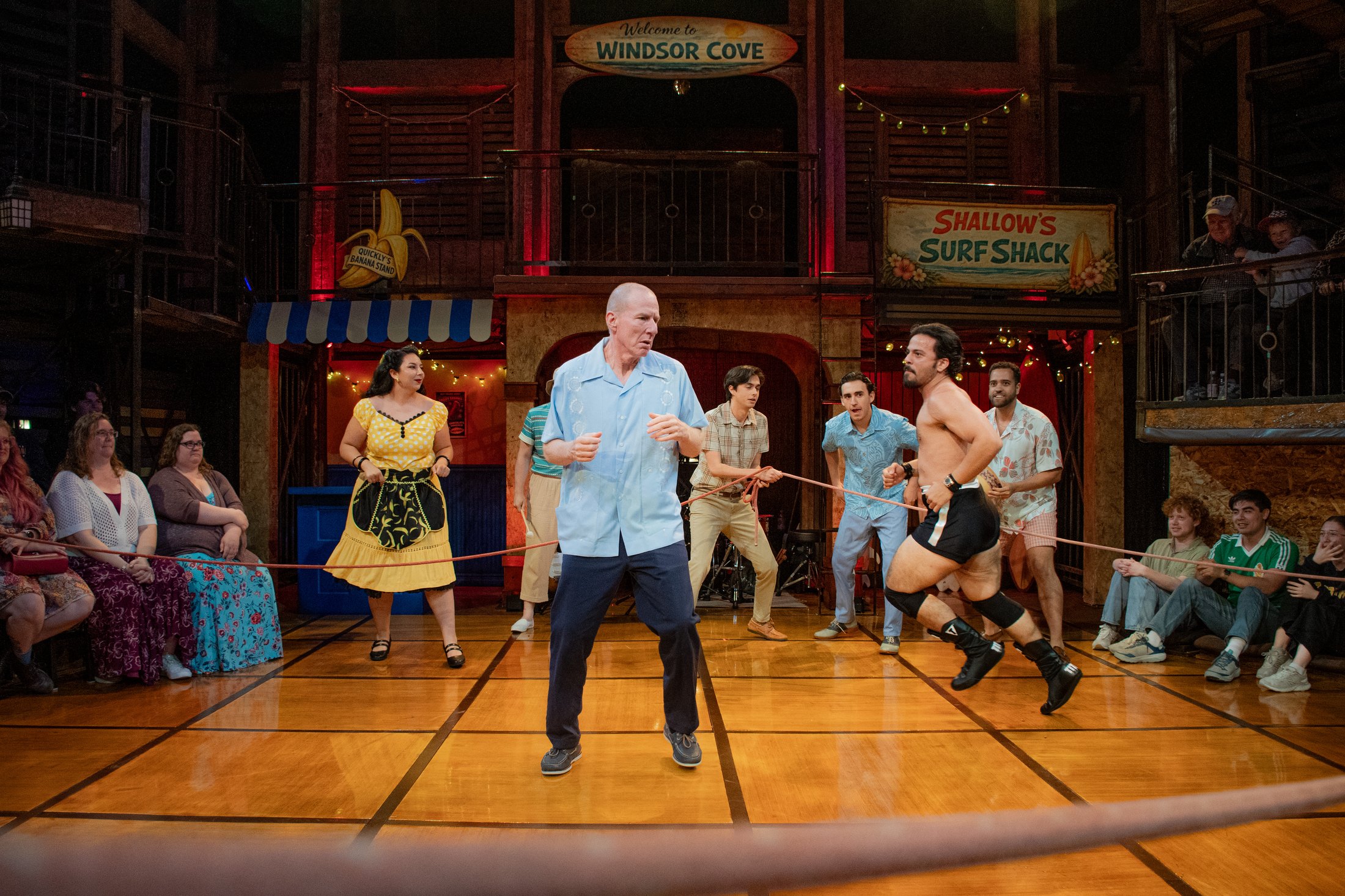 An ensemble scene reveals the architecture wrapping around performers and audience.