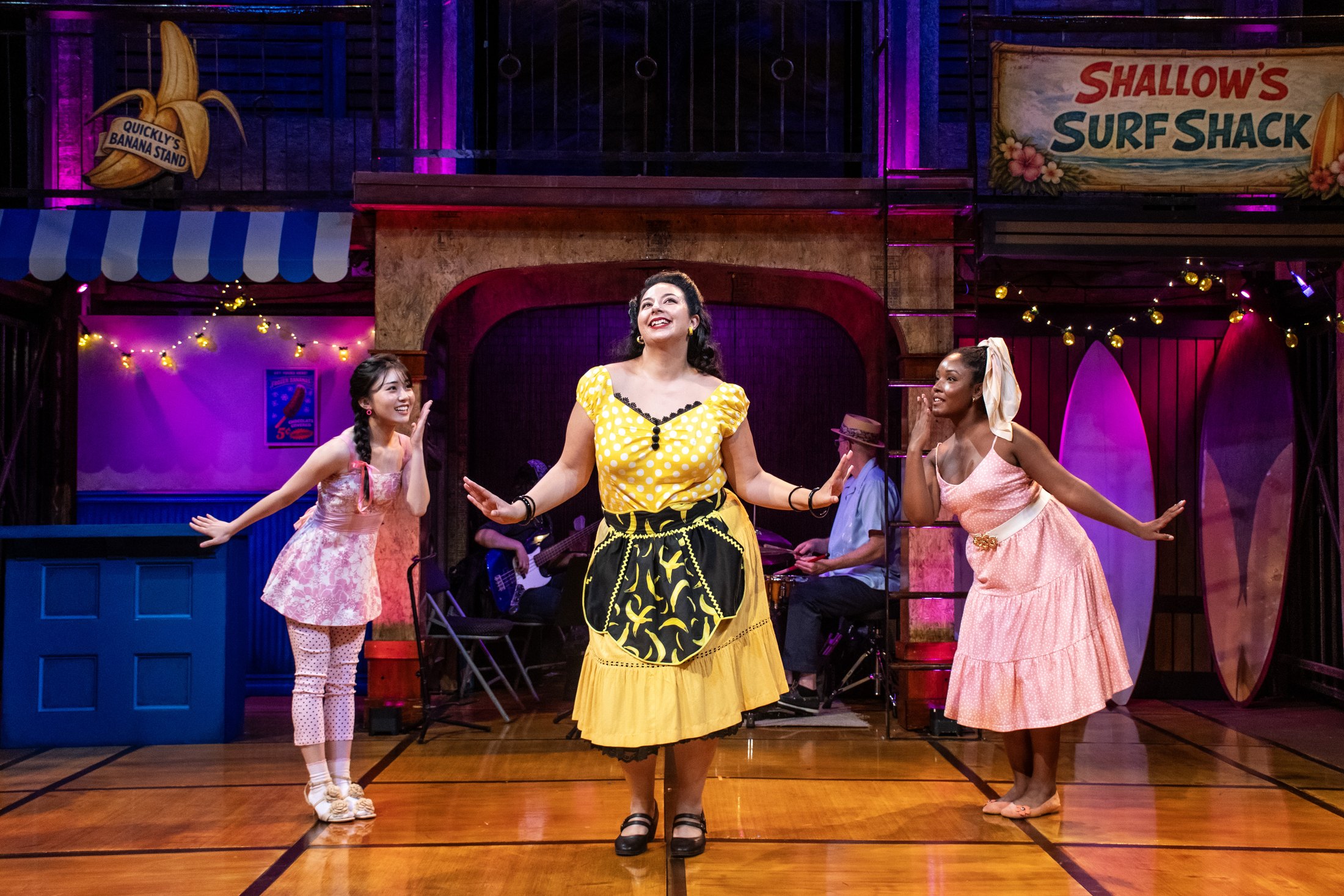 The women of Windsor Cove perform a musical number in front of the surf shack.