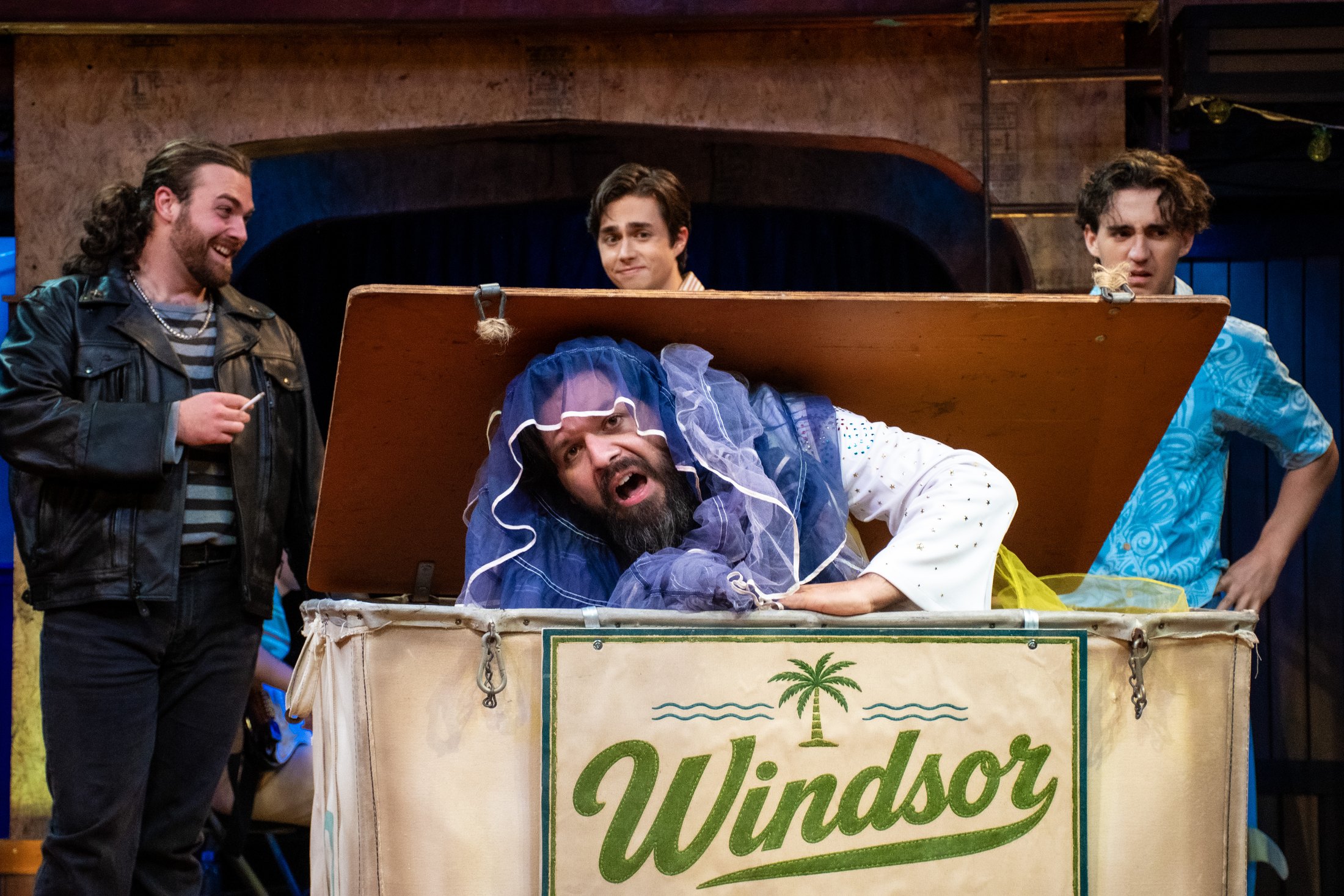 The Windsor Cove laundry-hamper scene plays against the central storefront.
