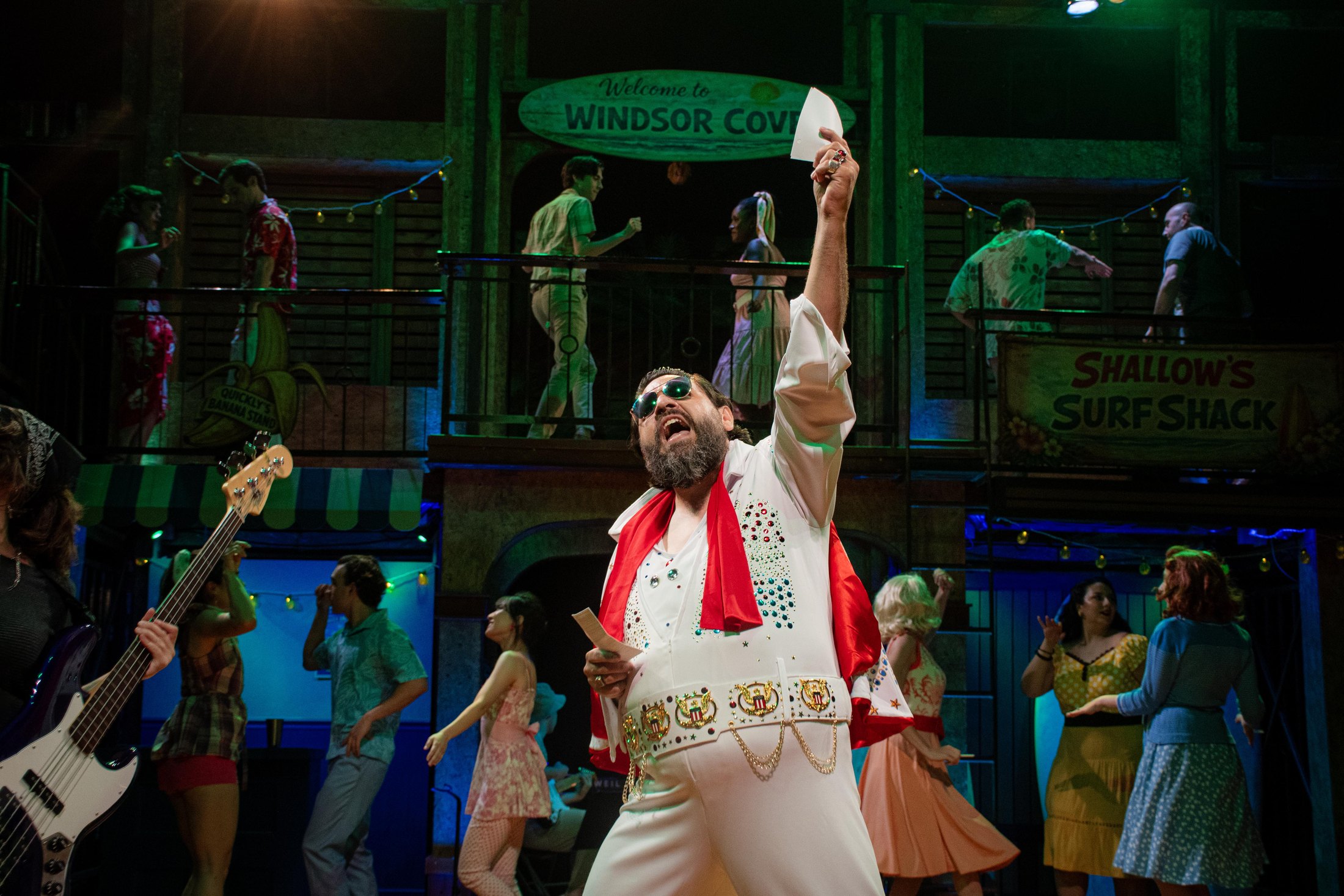 A nighttime musical moment reveals the scenic environment under green stage light.