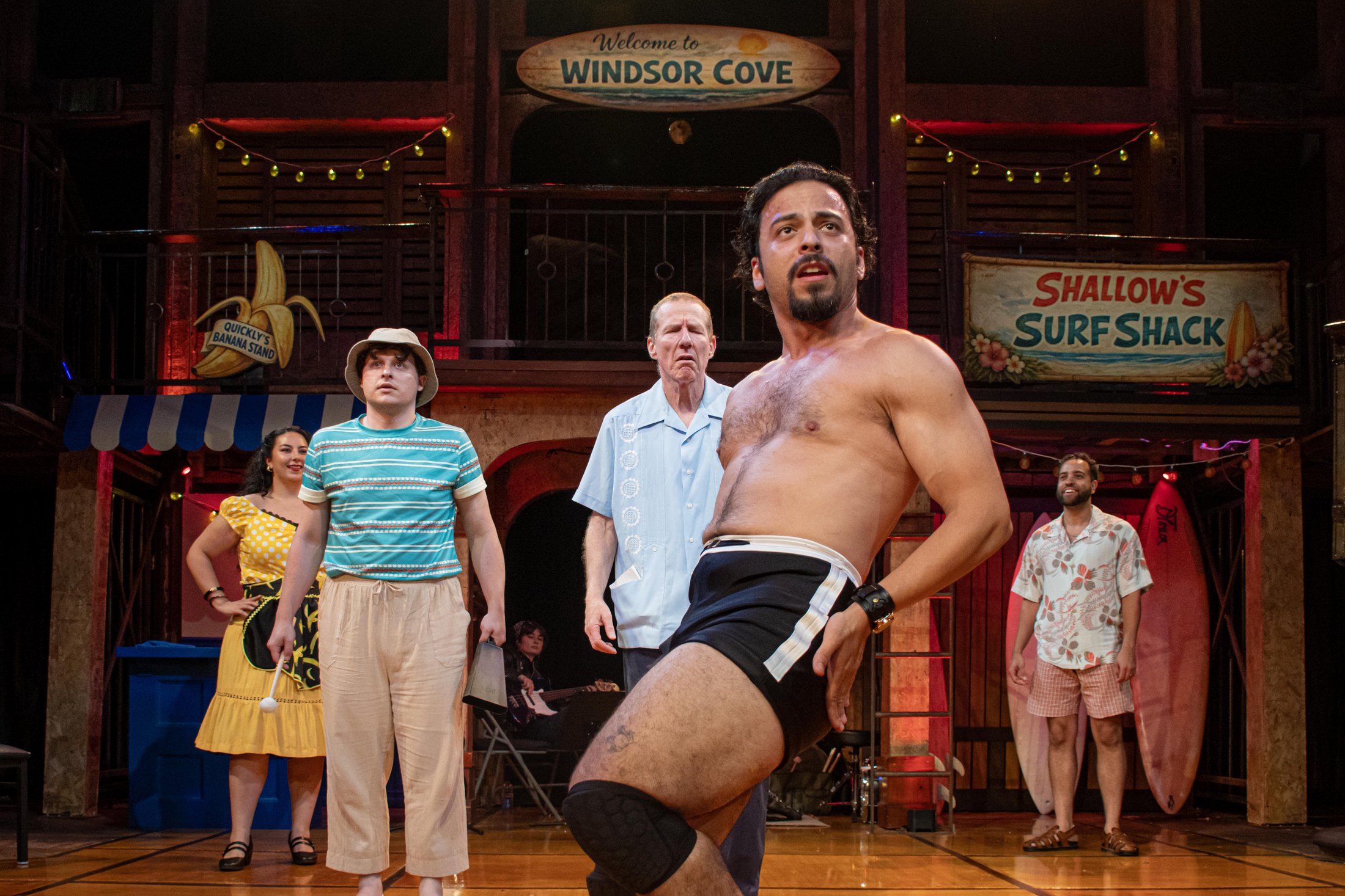 The company performs beneath the Windsor Cove and Shallow’s Surf Shack signs.