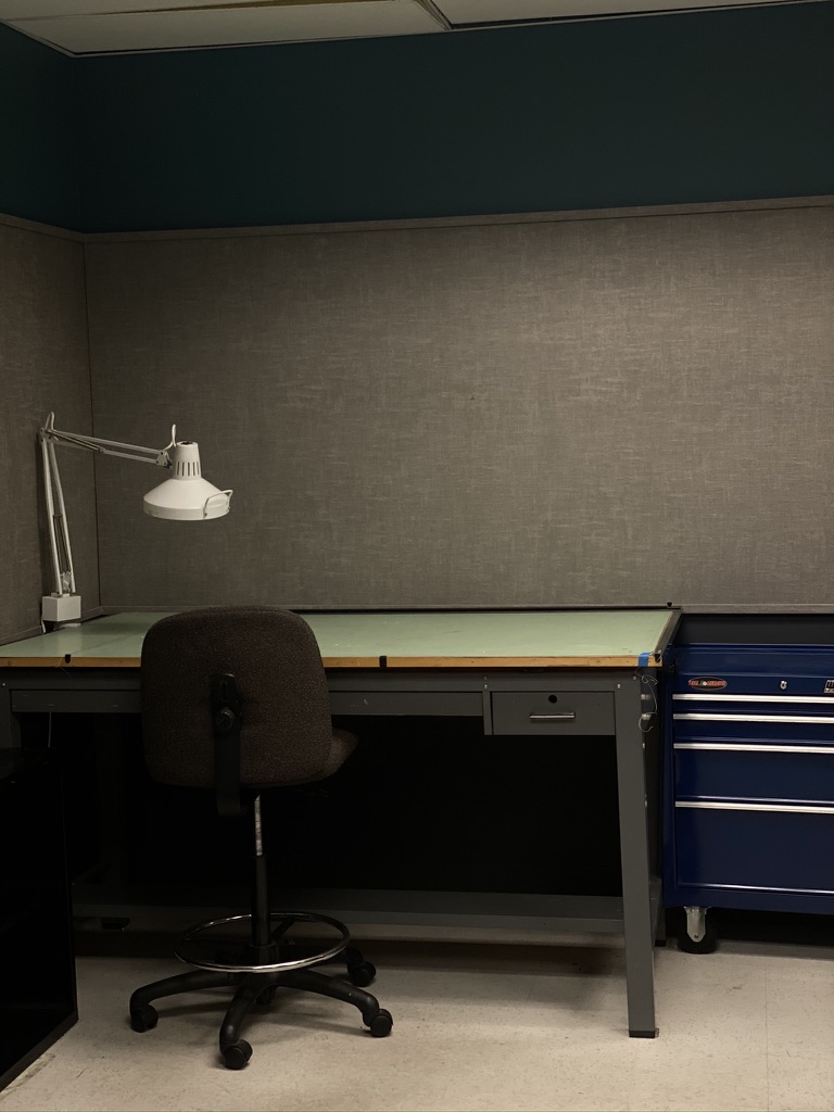 Drafting table, task lamp, chair, and tool chest in the studio