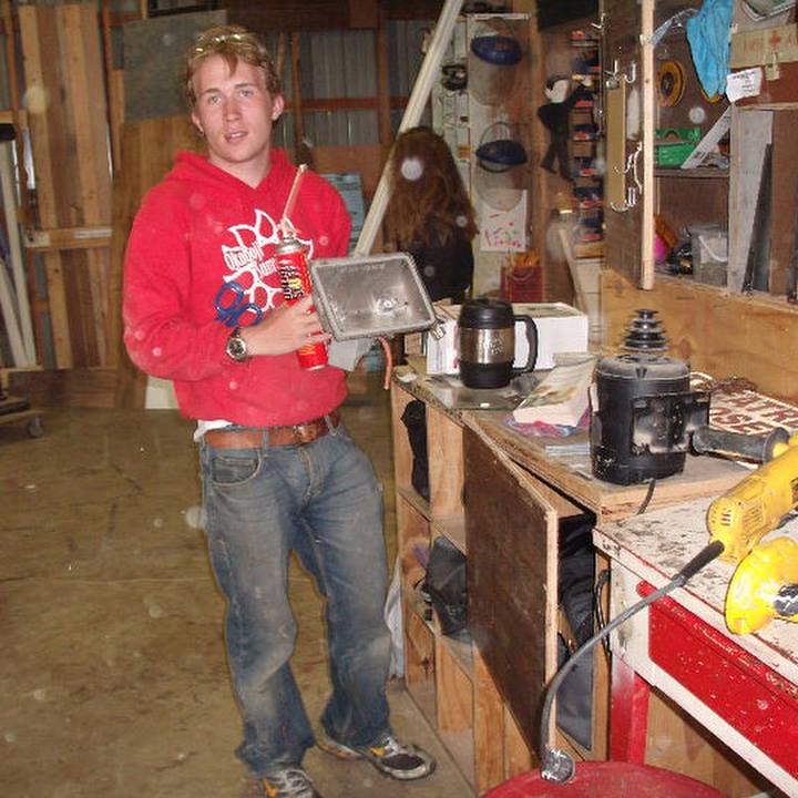 Brandon PT Davis at age 21 in the Okoboji Summer Theatre scene shop, standing beside tools and shop materials.