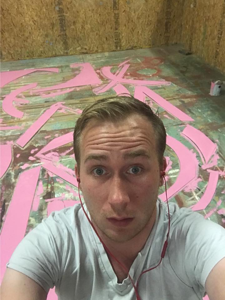 Brandon PT Davis at age 29 during Western Summer Theatre work, taking a selfie over a painted scenic floor.